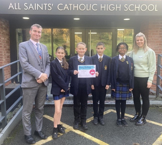 Photograph of pupil presenting cheque from the Penny Pinching Challenge